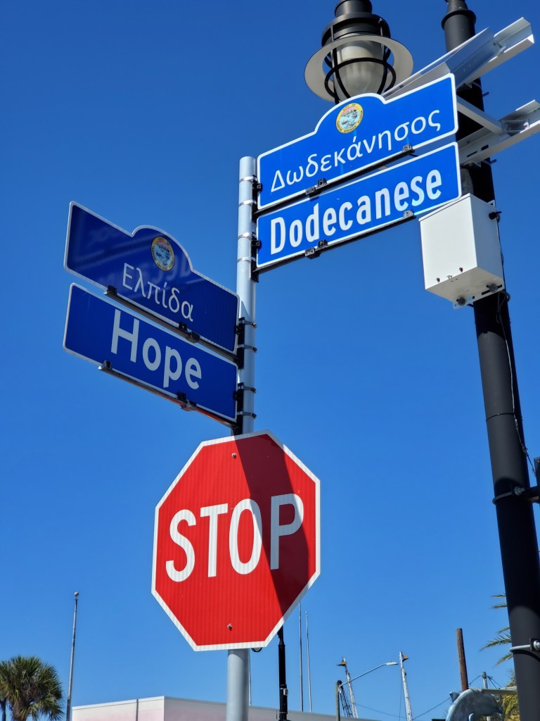 street sign and stop sign at Dodceanese Blvd and Hope St also shown in Greek language 