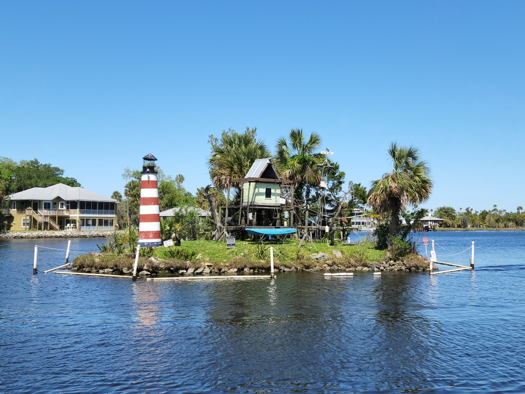 Small island in Homosassa with red and white striped lighthouse, and structure with ropes and platforms for monkeys 